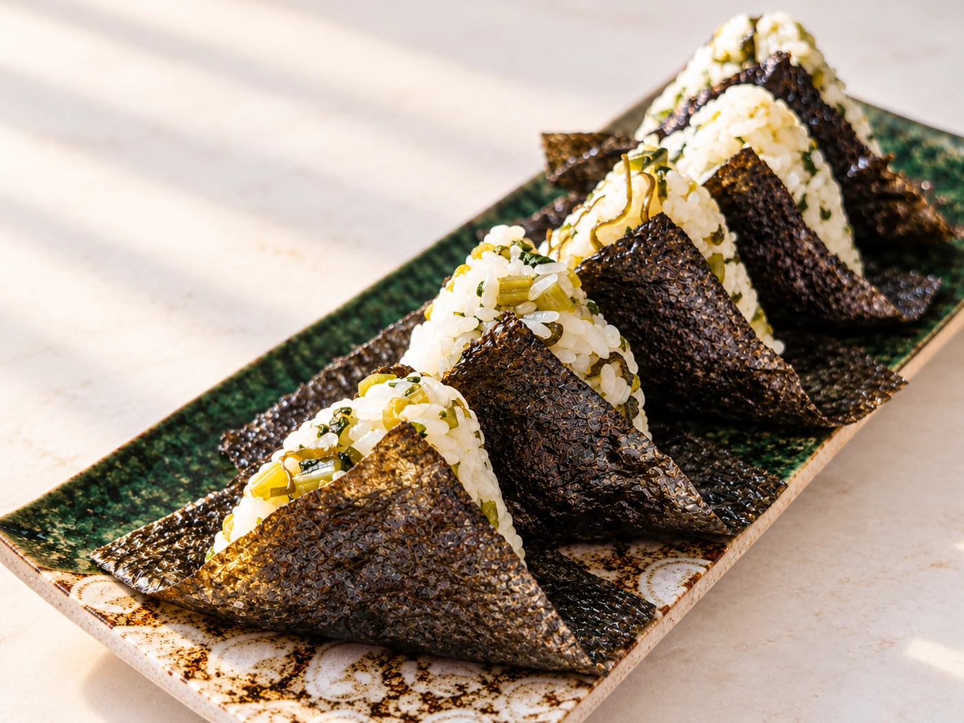 Onigiri rice balls with nori, served on a long ceramic plate